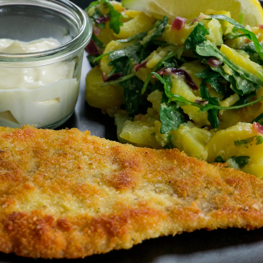 Paniertes Wolfsbarschfilet an Kartoffel-Rucola-Salat