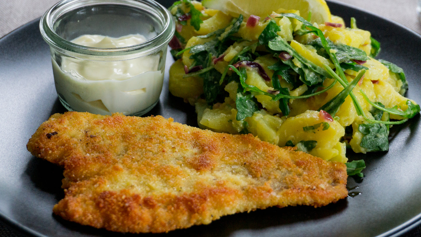 Paniertes Wolfsbarschfilet an Kartoffel-Rucola-Salat